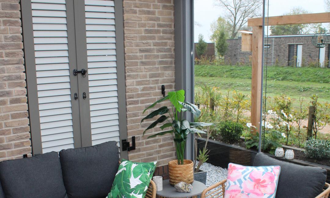 Ingerichte aluminium tuinkamer met glazen schuifwand